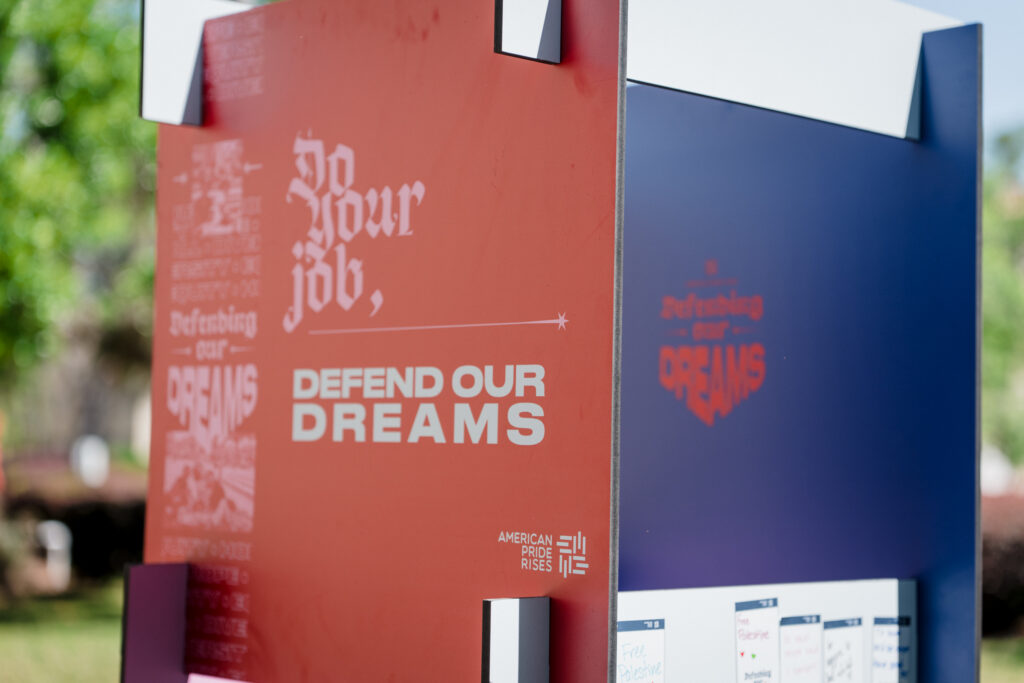 Defending Our Dreams tour participants holding a campaign sign